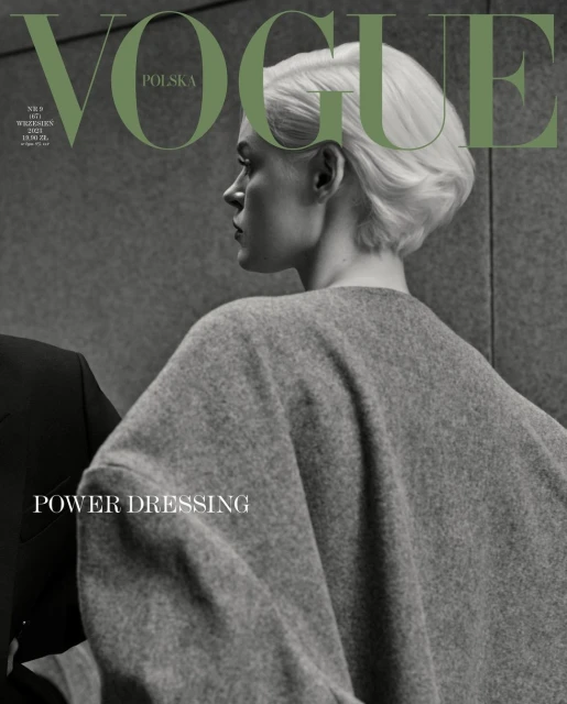 Fashion editorial cover of Vogue Polska with a woman in a gray wool coat, cropped haircut, and the Vogue logo in olive green.