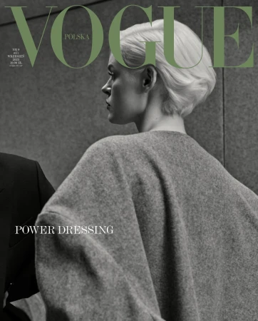 Fashion editorial cover of Vogue Polska with a woman in a gray wool coat, cropped haircut, and the Vogue logo in olive green.