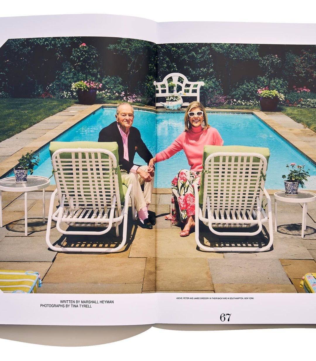 Couple seated in lawn chairs by a pool. The woman wears a pink sweater and floral pants, the man wears a blazer and pink shirt.