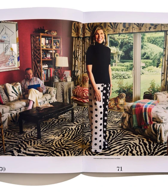 Interior shot with a woman in polka dot pants standing, and a man on a couch, featuring bold patterns and eclectic decor.