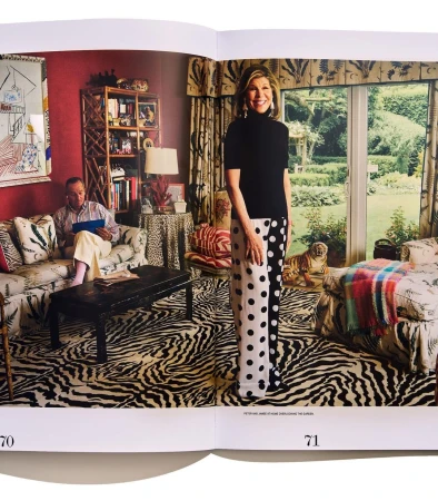 Interior shot with a woman in polka dot pants standing, and a man on a couch, featuring bold patterns and eclectic decor.