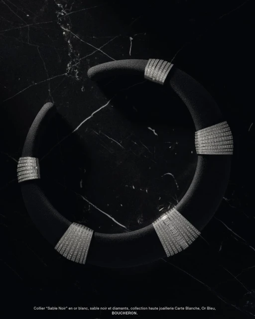 Boucheron Sable Noir white gold collar necklace with diamonds displayed on black marble background in a studio shot.