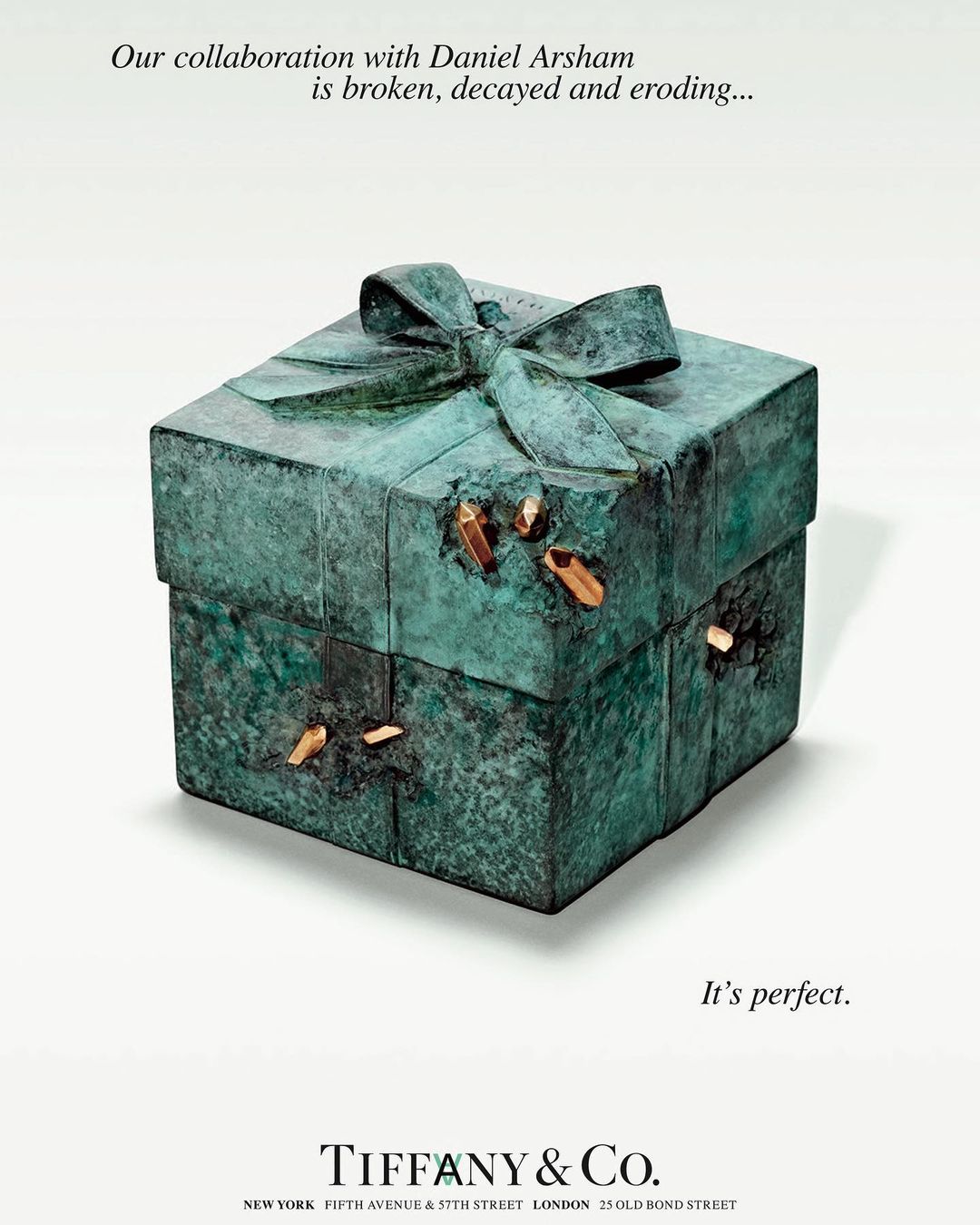 Patina green square gift box with ribbon and embedded gold pieces, advertisement for Tiffany & Co. collaboration with Daniel Arsham.