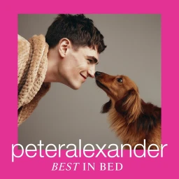 Man wearing a brown bathrobe touching noses with a long-haired dachshund against a grey backdrop inside a pink border