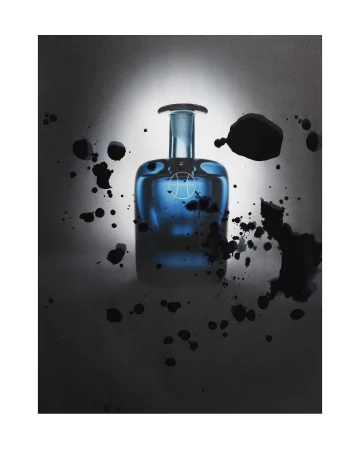 Studio shot of a blue glass perfume bottle with an abstract logo, surrounded by dark ink splashes against a white and grey gradient background.