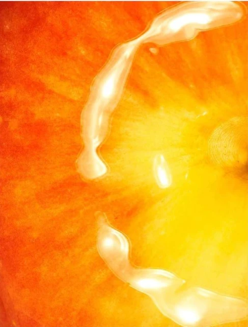 Abstract close-up of vibrant yellow and orange hues with pearlescent streaks, evoking a sense of warmth and luminosity in an artistic manner.