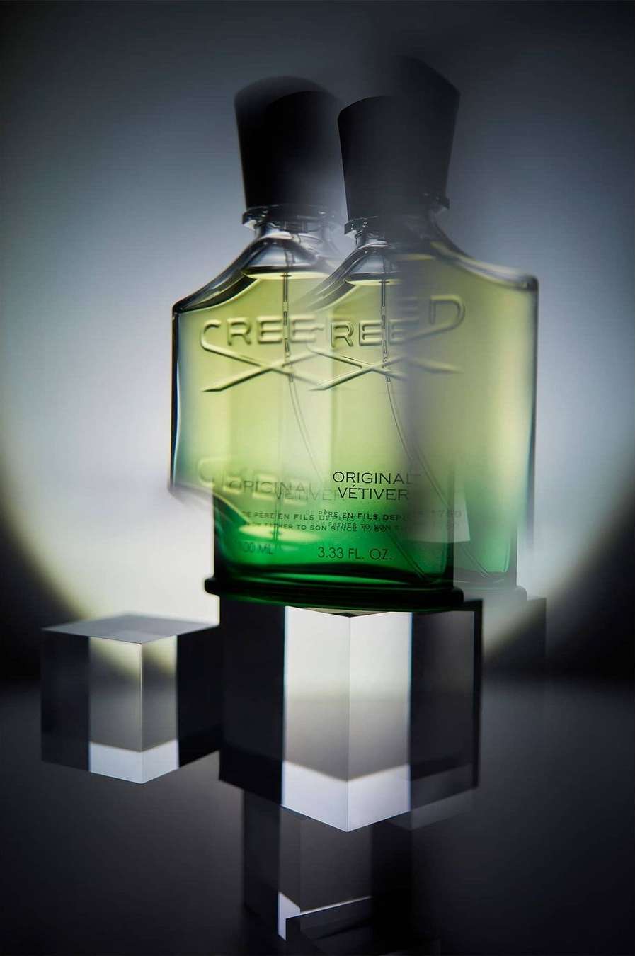 Studio shot of two Creed Original Vetiver perfume bottles on clear acrylic cubes, showcasing luxury fragrance and minimalist design.