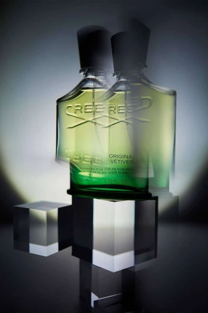 Studio shot of two Creed Original Vetiver perfume bottles on clear acrylic cubes, showcasing luxury fragrance and minimalist design.
