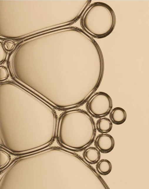 Macro photograph of connected translucent bubbles against a neutral backdrop, showcasing abstract patterns and refractions.