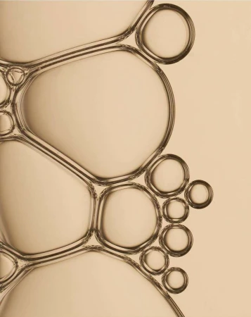 Macro photograph of connected translucent bubbles against a neutral backdrop, showcasing abstract patterns and refractions.