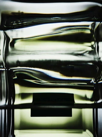 Abstract close-up of a clear, textured glass object with dark horizontal bands, highlighting its shape and form.