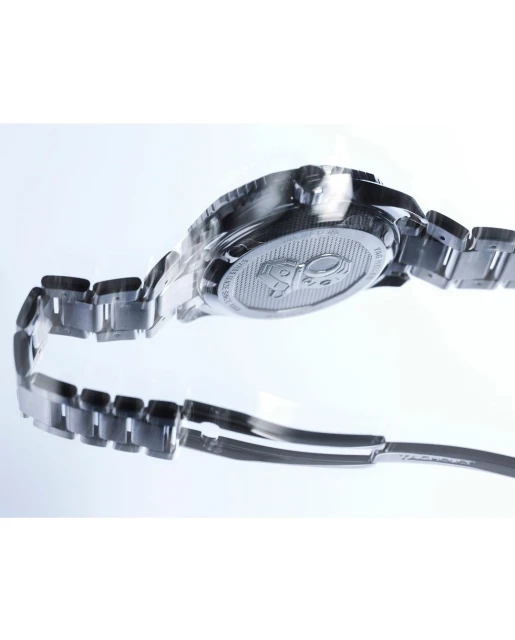 Back view of a silver TAG Heuer wristwatch with a metal bracelet on a reflective white surface in a studio setting. 