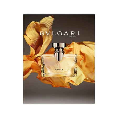 Bvlgari Iris d'Or perfume bottle surrounded by flowing golden yellow fabric against a dark background