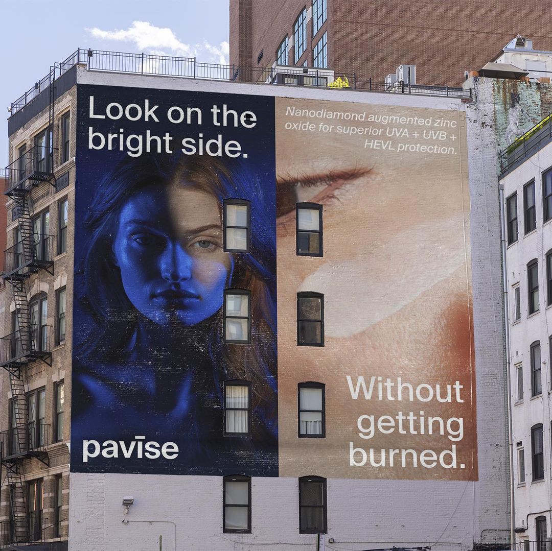 Outdoor advertising featuring a split-face beauty advertisement on a building wall, with text promoting skin protection and the brand 'pavise'.