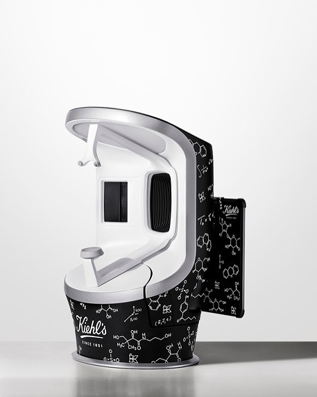 Kiehl's skin analysis device on a white surface. The device has a black and white pattern of science diagrams all over it.