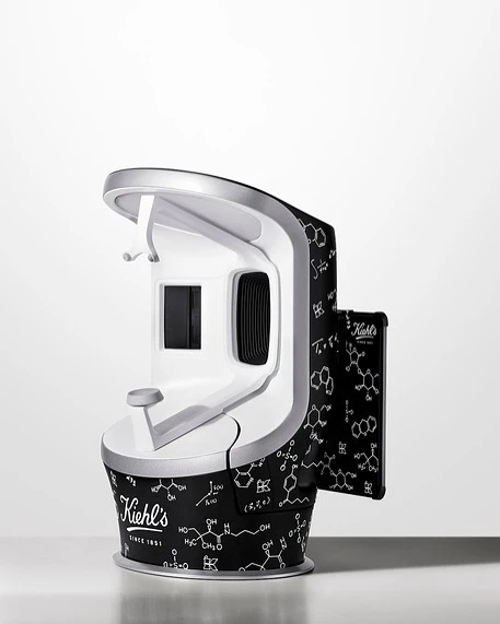 Kiehl's skin analysis device on a white surface. The device has a black and white pattern of science diagrams all over it.