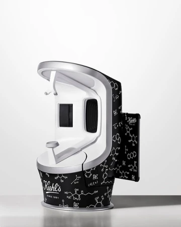 Kiehl's skin analysis device on a white surface. The device has a black and white pattern of science diagrams all over it.