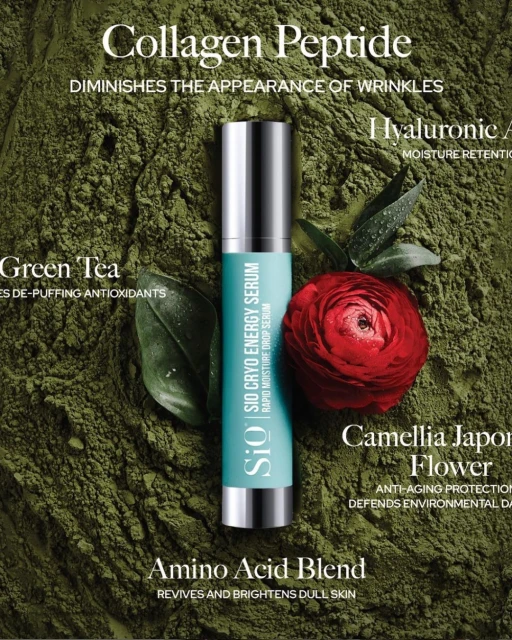 Close-up studio shot of skincare serum surrounded by flower and green tea leaves on an olive green powder background.