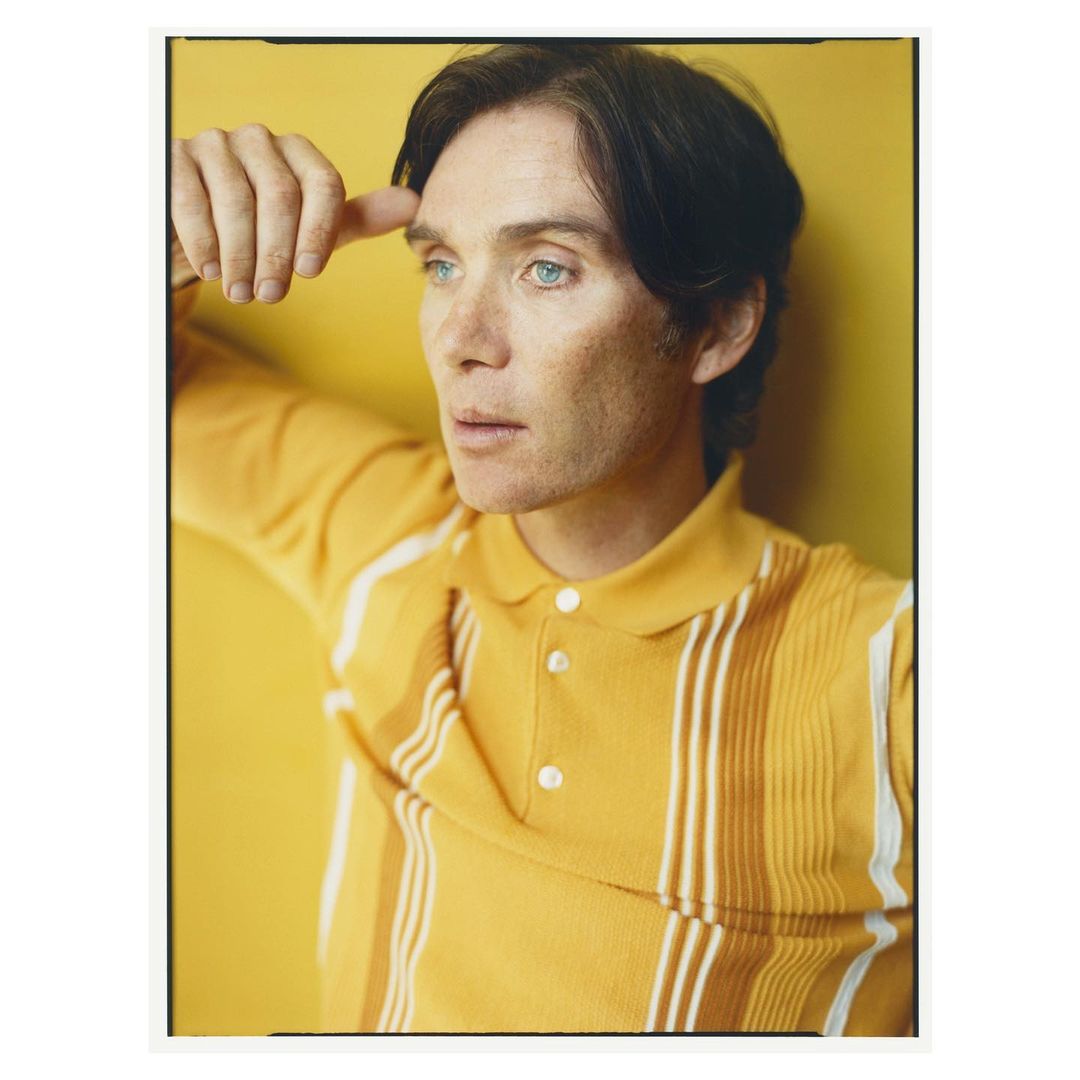 Portrait of a light-skinned adult male with dark hair wearing a yellow polo shirt against a yellow backdrop in a photo studio.