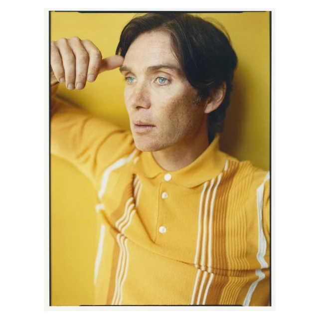 Portrait of a light-skinned adult male with dark hair wearing a yellow polo shirt against a yellow backdrop in a photo studio.