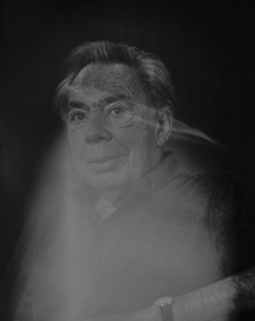 Black and white portrait of older adult male with light hair wearing collared shirt against a dark background with a ghosting effect.