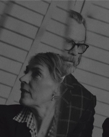 Double exposure portrait of an older woman and an older man wearing glasses, photographed by Tom Jamieson in New York.