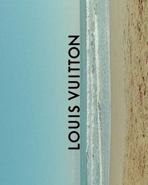 Beach scene with waves washing ashore on tan sand under a clear blue sky, featuring vertical text overlay of the Louis Vuitton brand.