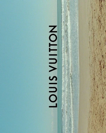 Beach scene with waves washing ashore on tan sand under a clear blue sky, featuring vertical text overlay of the Louis Vuitton brand.