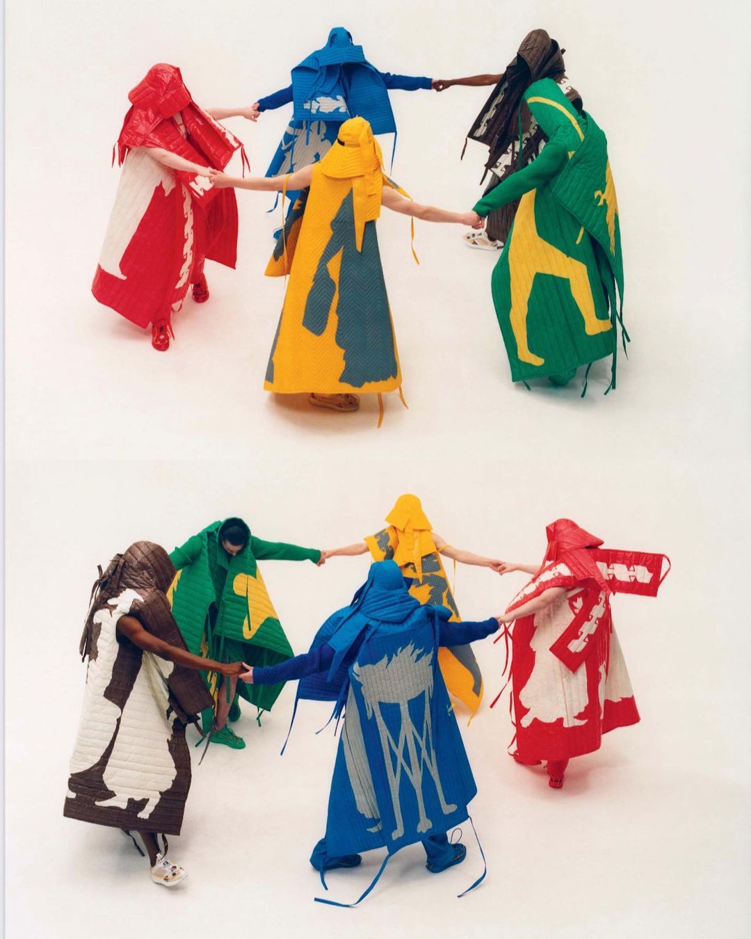 Eight people in hooded, colorful, and patterned garments hold hands in a circle on a white background. Abstract and striking apparel.
