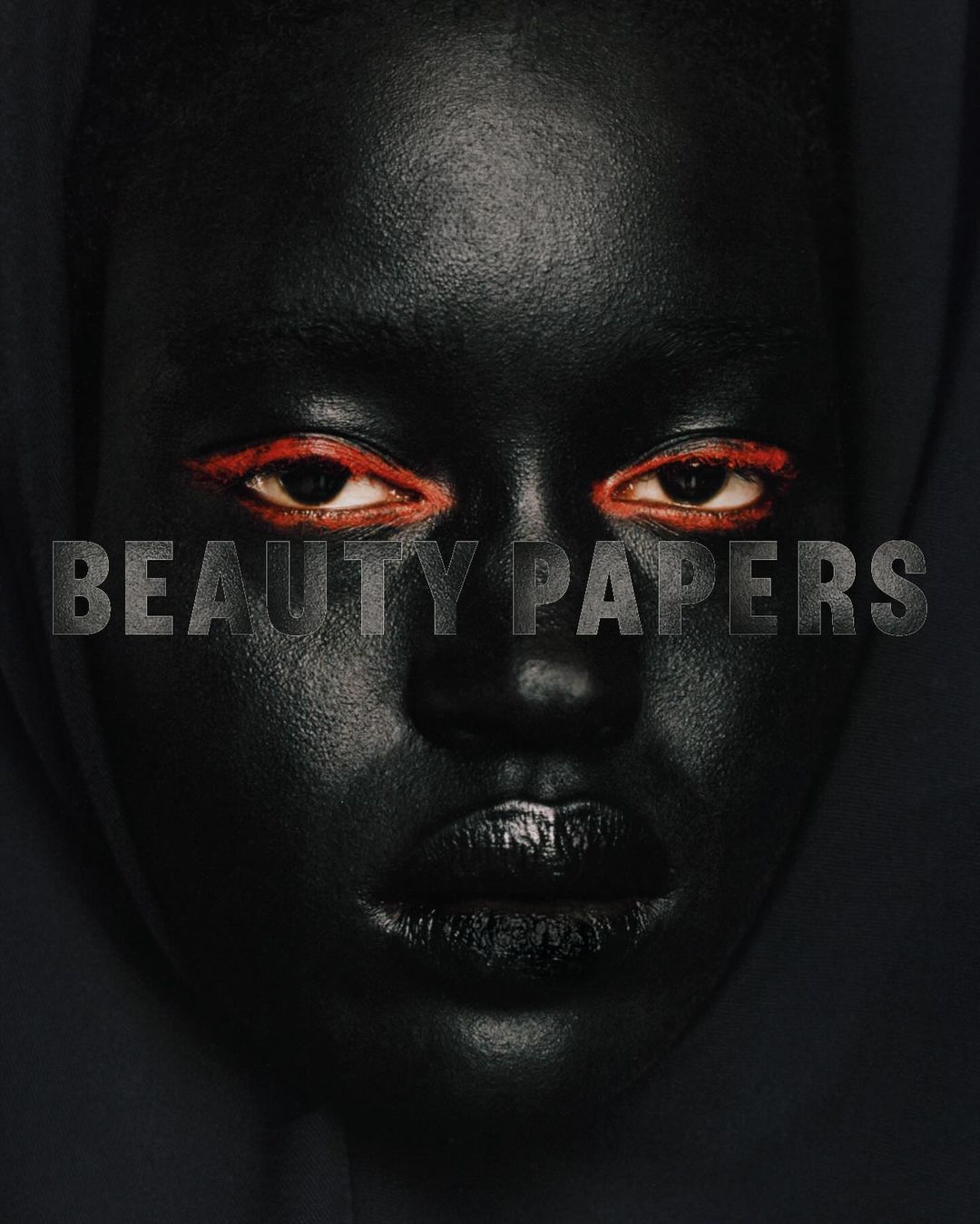 Close-up portrait of a dark-skinned woman with vibrant red eyeliner, black lipstick, and 'BEAUTY PAPERS' text overlayed.