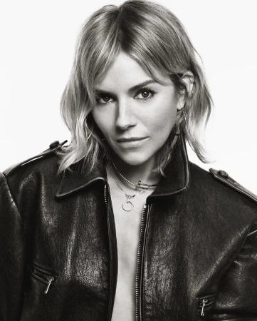 Portrait of actress Sienna Miller wearing a black leather jacket against a seamless white background, photographed by Tom Schirmacher.