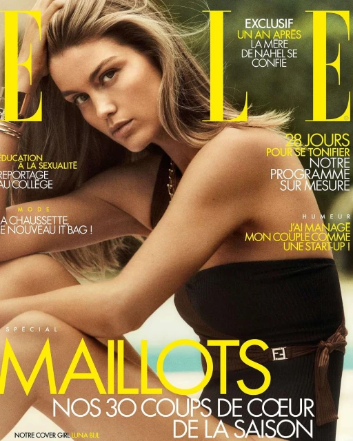 Elle magazine cover featuring a model in a black swimsuit, with the masthead and cover lines in yellow and white text, indoor photo studio.