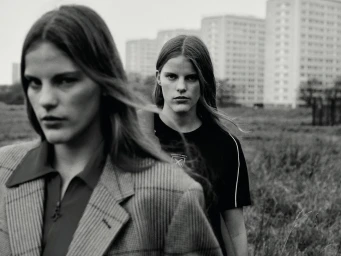 Monochrome fashion portrait of two female models outdoors with apartment buildings in the background shot by Tom Sloan