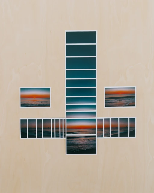 Collage of ocean sunset photographs arranged in a cross shape on a beige wooden surface, creating a unique and artistic composition.