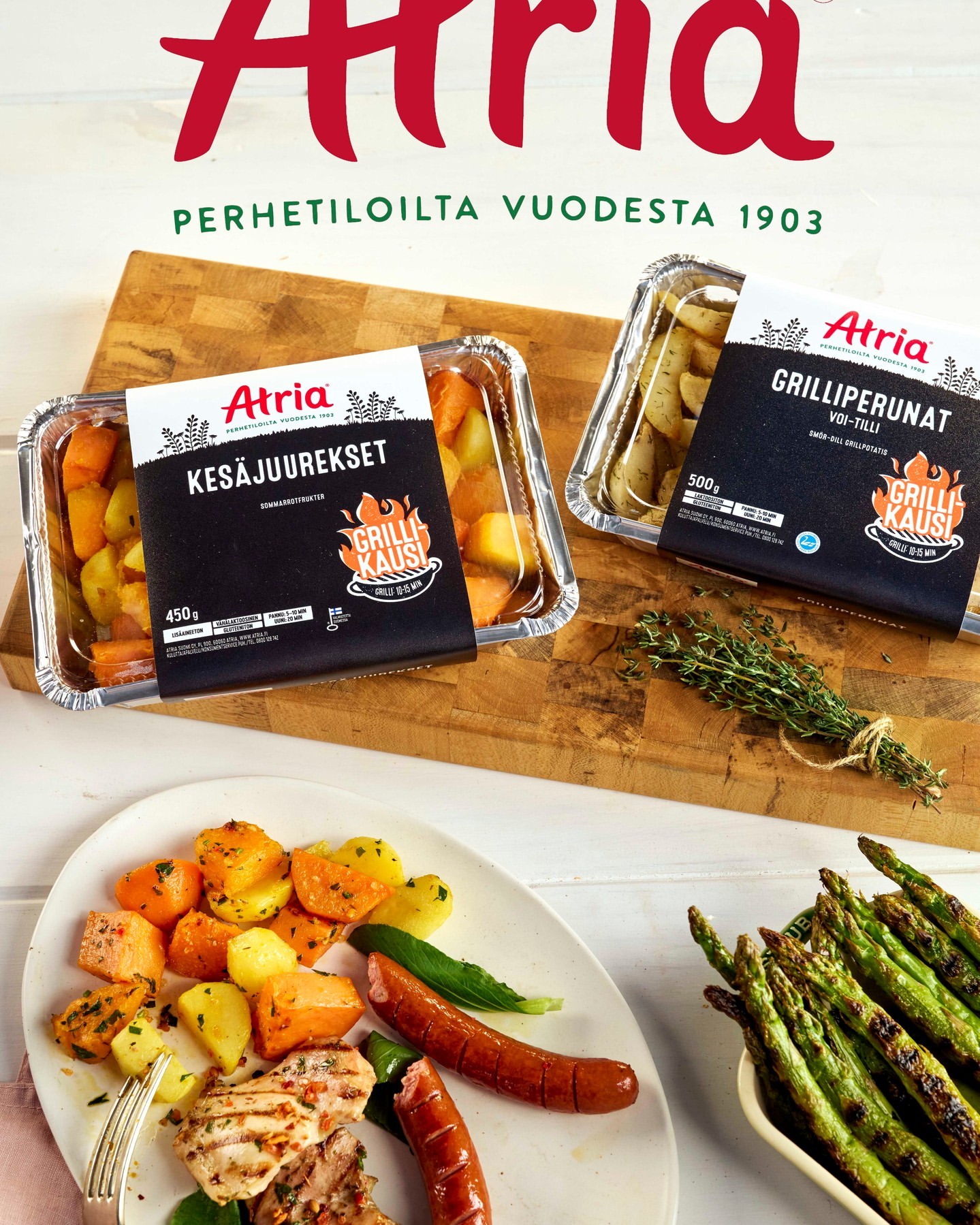 Overhead food photography of Atria ready-to-cook meal packages and prepared grilled meat, potatoes, vegetables, and asparagus.