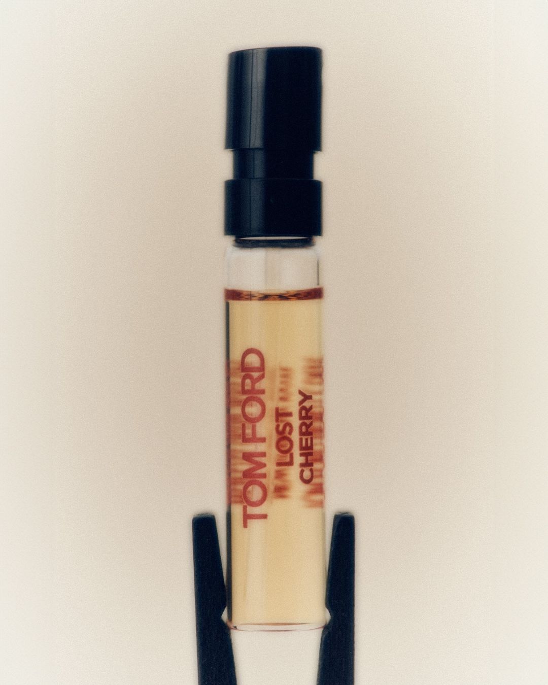 Tom Ford Lost Cherry perfume sample vial with black cap on white background for beauty and fragrance product shot.
