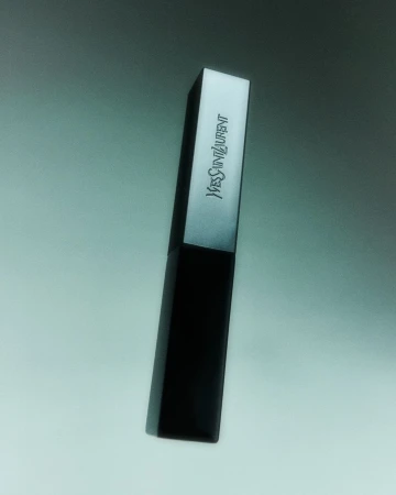 Yves Saint Laurent lipstick tube. Beauty shot of a black and silver YSL lipstick tube against a grey background. Beauty and fashion product.