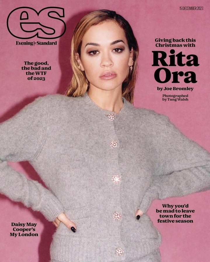 Evening Standard magazine cover featuring Rita Ora in a grey cardigan and skirt, against a pink background with magazine text overlays.