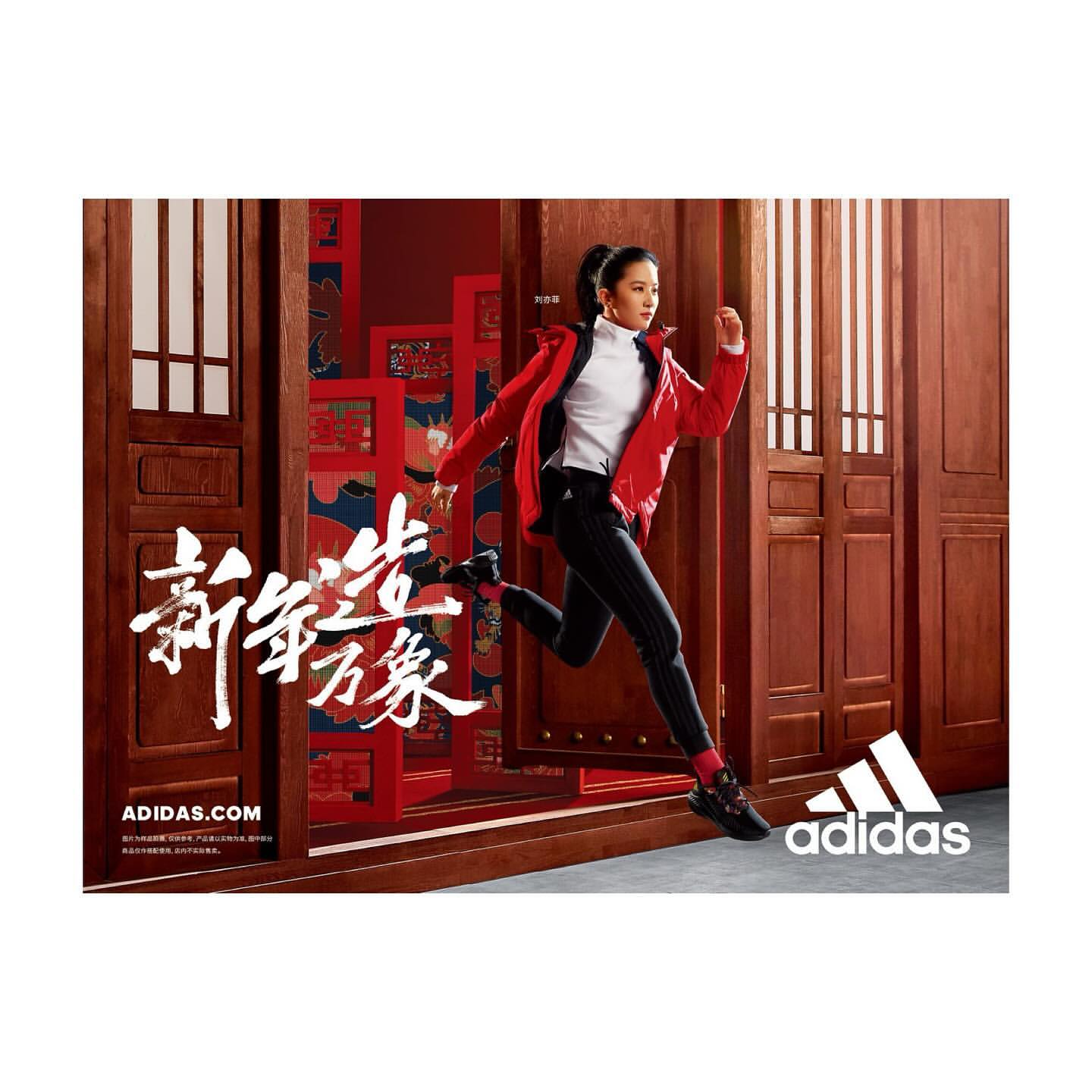 A woman in sportswear is captured mid-stride against a backdrop of traditional red doors, promoting athletic apparel by Adidas.