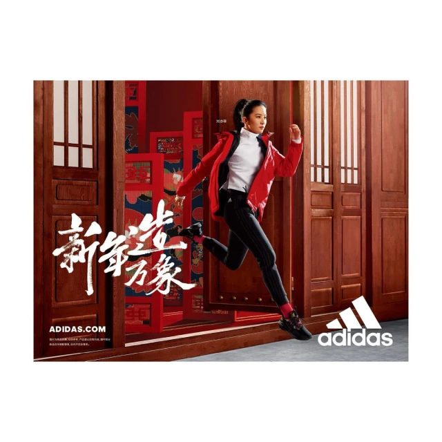 A woman in sportswear is captured mid-stride against a backdrop of traditional red doors, promoting athletic apparel by Adidas.
