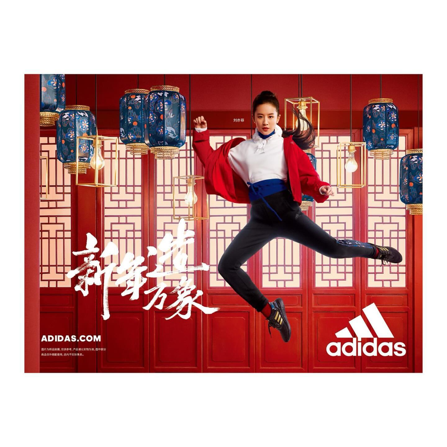 Athletic woman in Adidas activewear leaps against a red backdrop with Asian-style lanterns for an Adidas promotion; logo visible.