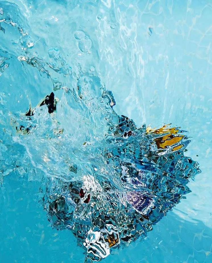 Underwater photography of clear turquoise water with dynamic splash, creating a visually captivating abstract composition, high angle view.