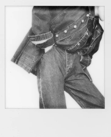 Close-up portrait of a person in a denim jacket and jeans, shot on instant film with a white border.