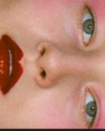Extreme close-up portrait of a woman wearing dark red lipstick and pink eyeshadow photographed by Turkina Faso.