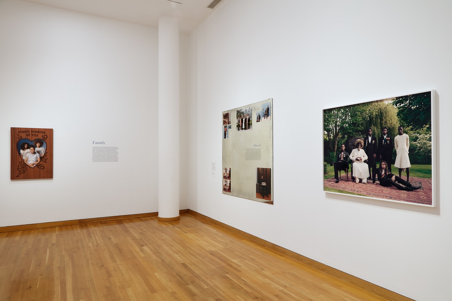 Interior view of an art gallery displaying photographic portraits of people in various settings and styles in a modern art space.