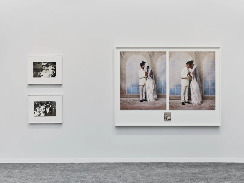 Three framed photographs are displayed on a white wall: two smaller monochrome images and a large color image of a wedding couple.