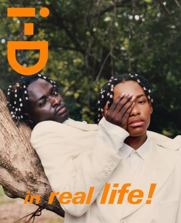 Two black men in cream suits outdoors with beaded braids, photographed by Tyler Mitchell.