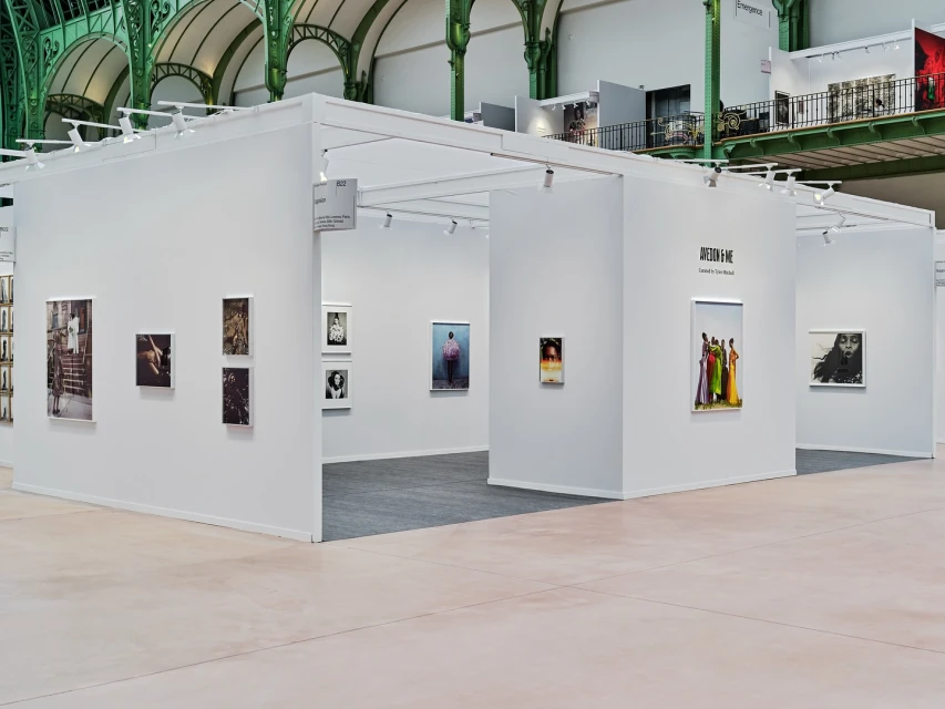 An exhibition hall presents artwork in a modern gallery space with white walls, recessed lighting, and a smooth floor, creating a clean setting.