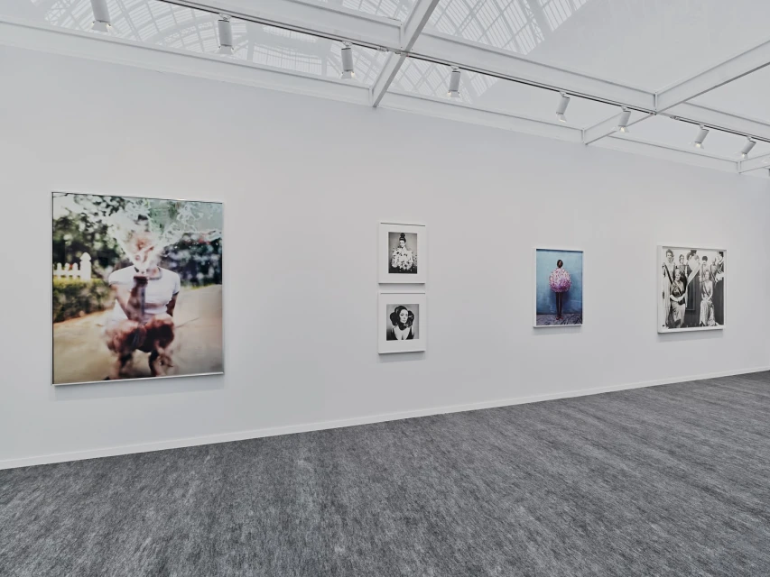 Art gallery exhibition featuring framed photographic portrait art, showcasing a variety of subjects and styles on a light wall.