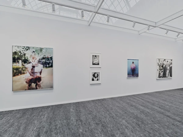 Art gallery exhibition featuring framed photographic portrait art, showcasing a variety of subjects and styles on a light wall.